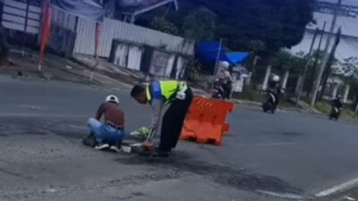 Cegah Lakalantas, Personel Satlantas Polres OKUS Tambal Jalan Berlubang di Seputar Pasar Muaradua